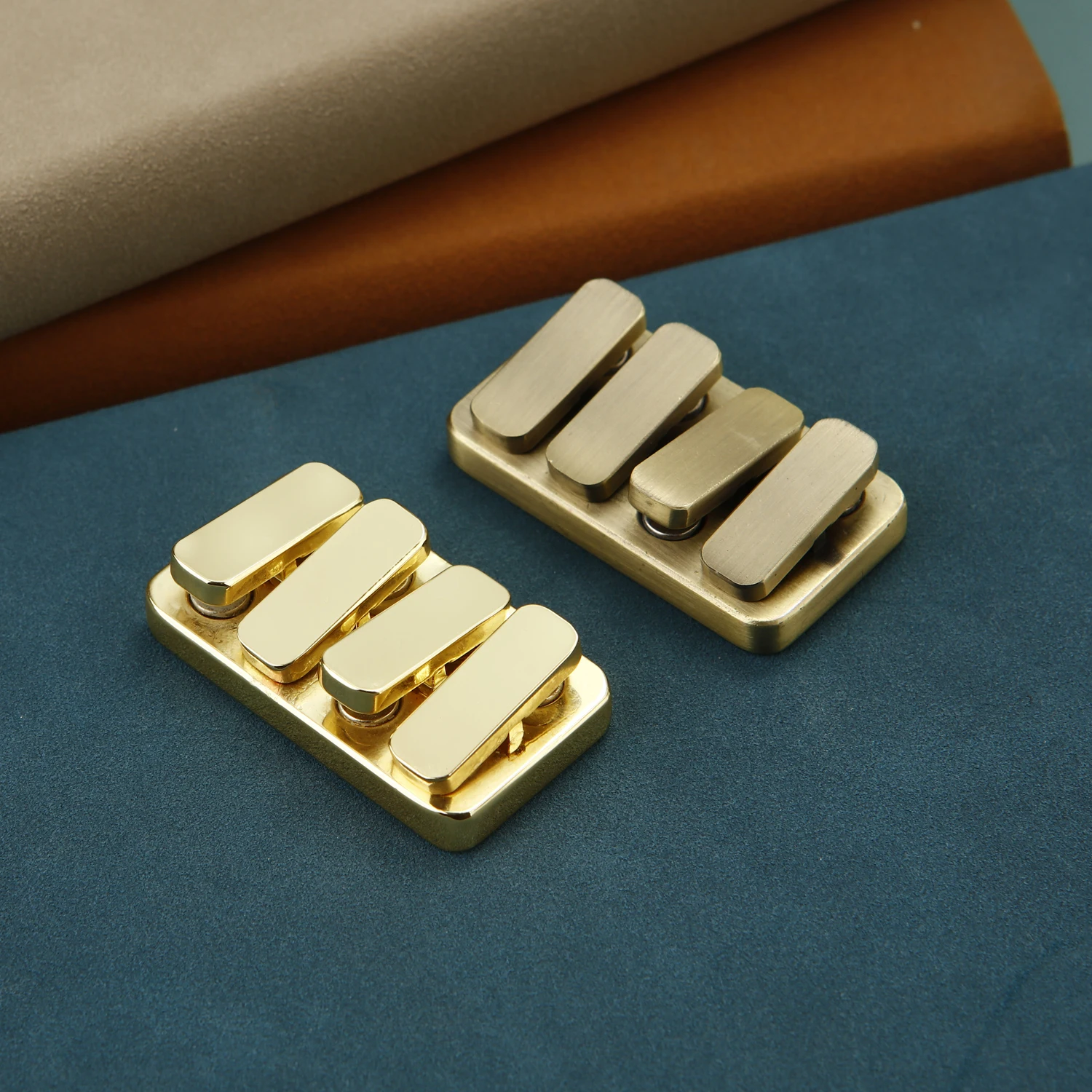 Two brass magnetic sliders on a desk