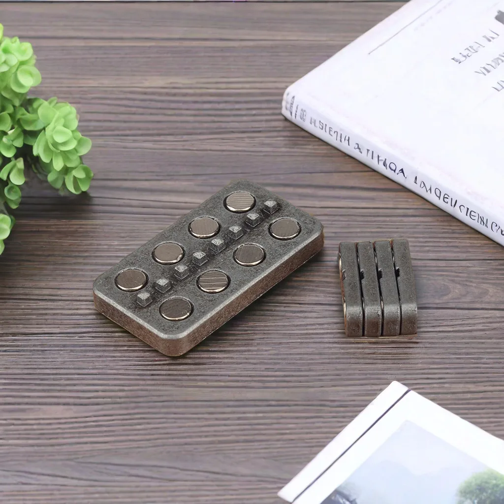 A steel slider resting on a desk beside a book